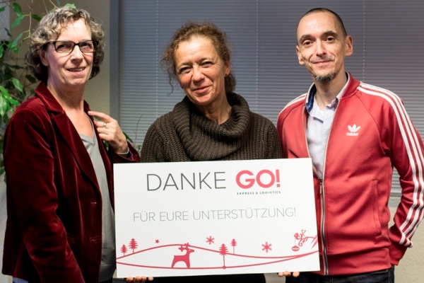 Mitarbeiter von GO! halten Check in der Hand